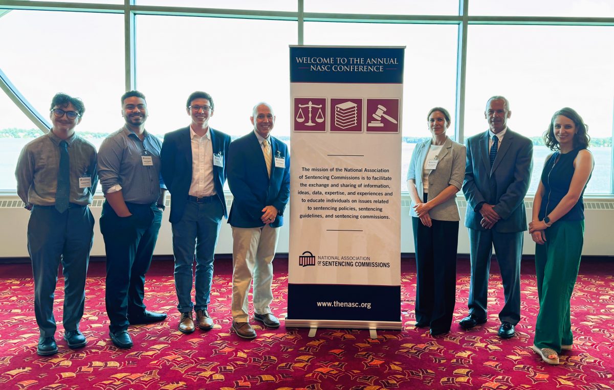 a group of conference attendees by a sign