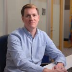 a man in a blue shirt looking at the camera