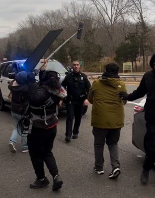 a filming scene on the side of a roadway