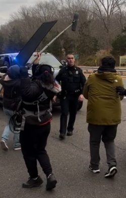 a filming scene on the side of a roadway